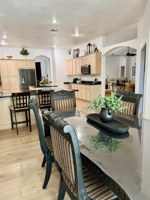 Family-style dining table set for six, open to the kitchen beyond.